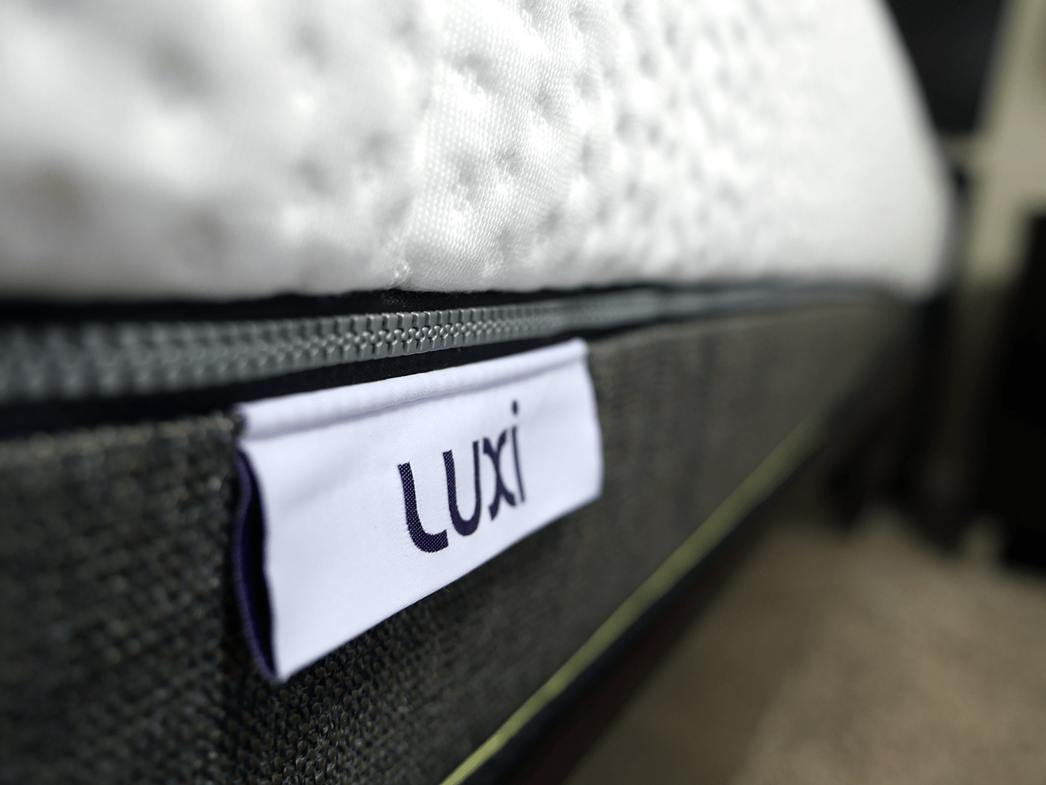 Close up shot of the Luxi mattress logo