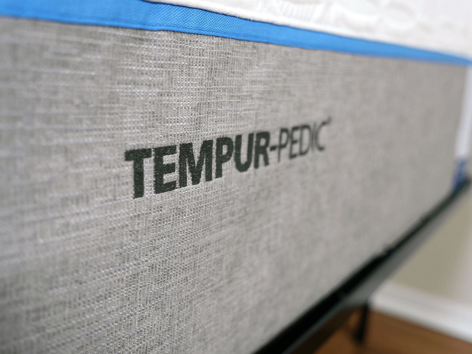 Close up shot of the Tempurpedic logo embossed to the foot of the mattress