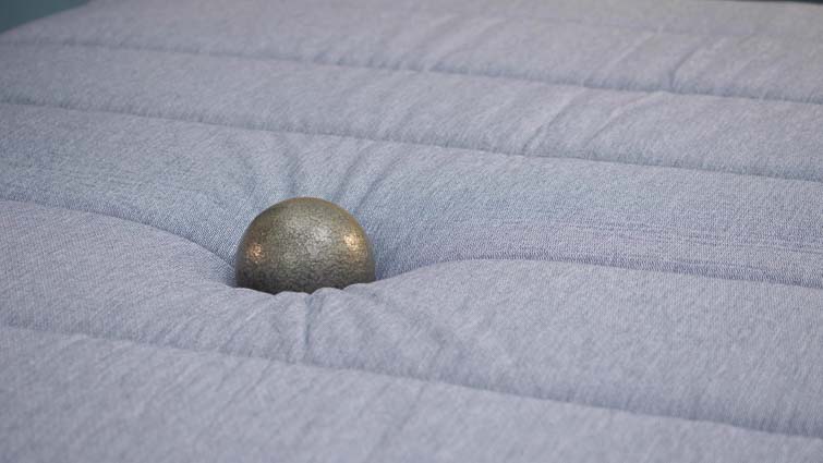 Tuft & Needle Hybrid mattress ball on bed