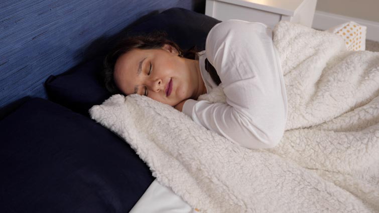 woman sleeping under weighted blanket