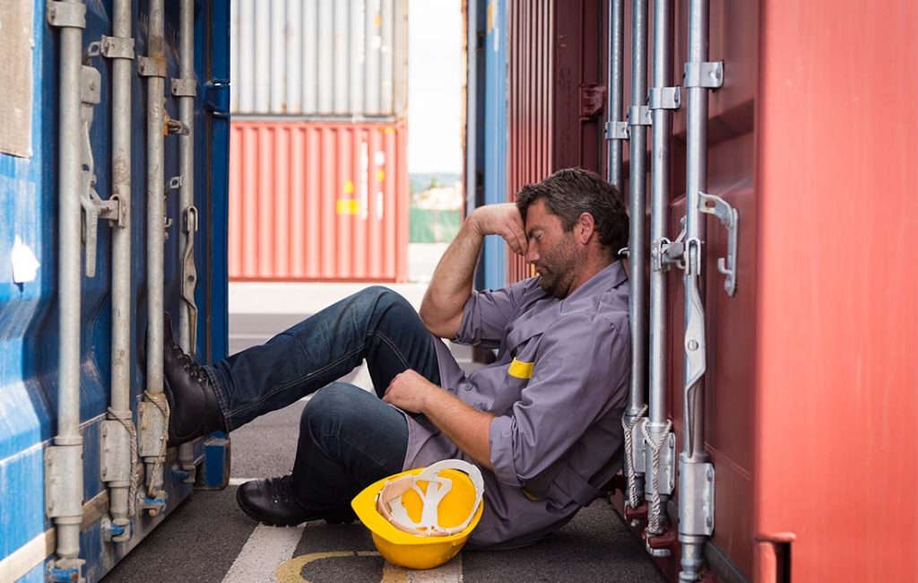 Close-up shot of a man sleeping between containers