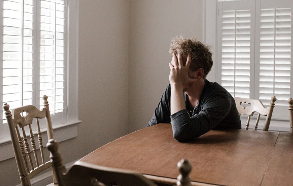 person frustrated at kitchen table