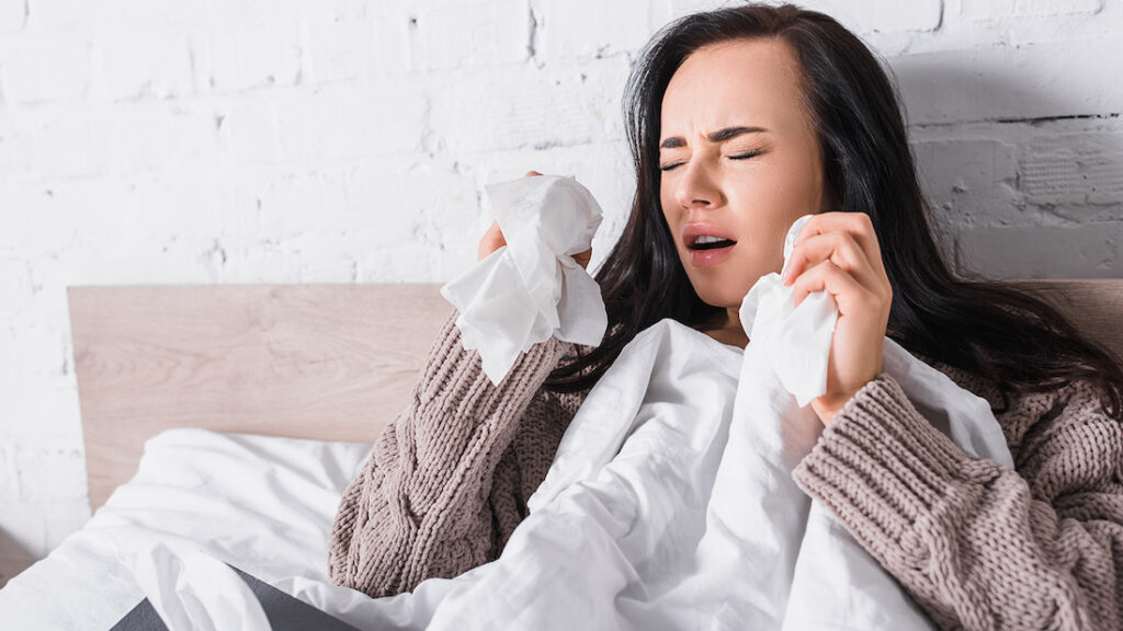 can you sneeze in your sleep? Woman sneezing 