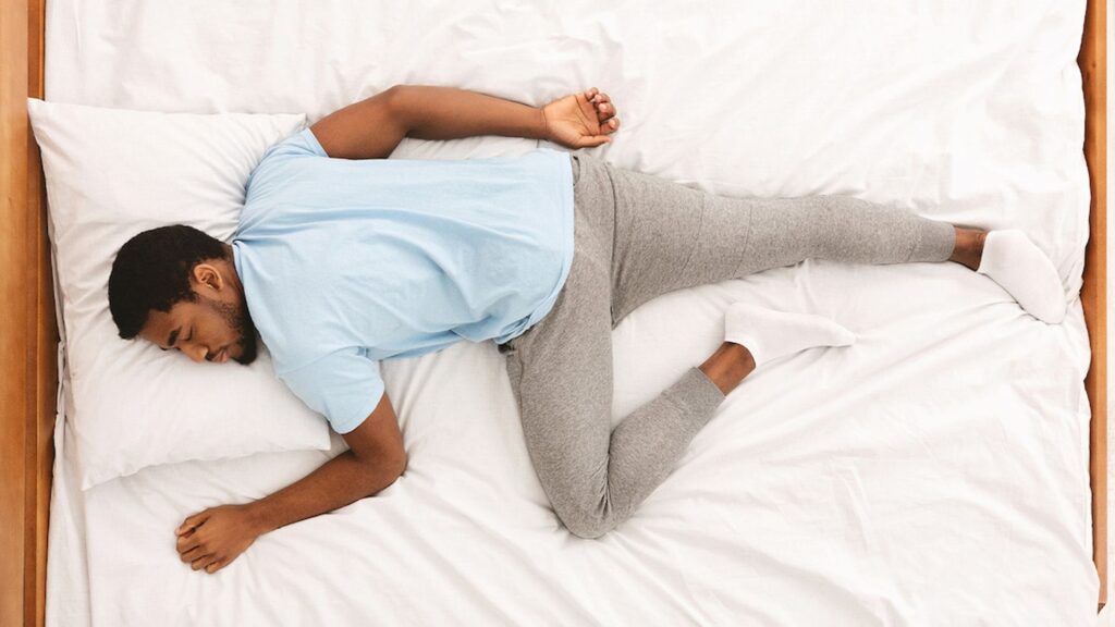 man on bed experiencing peridic limb movement disorder