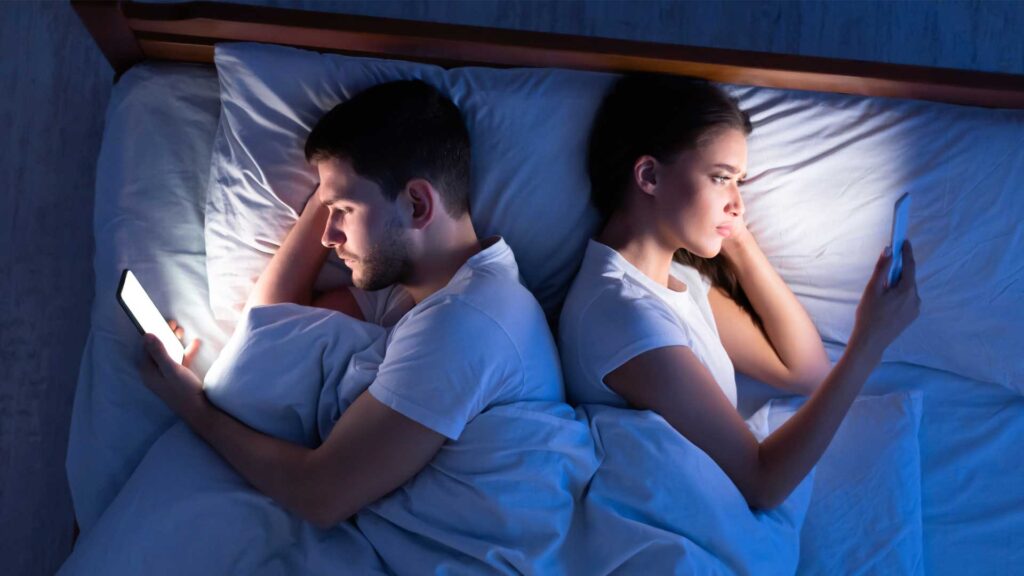 tech devices in bed iStock 1202961034