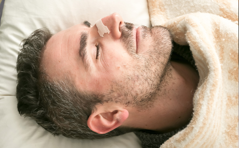 man sleeping with nose strip