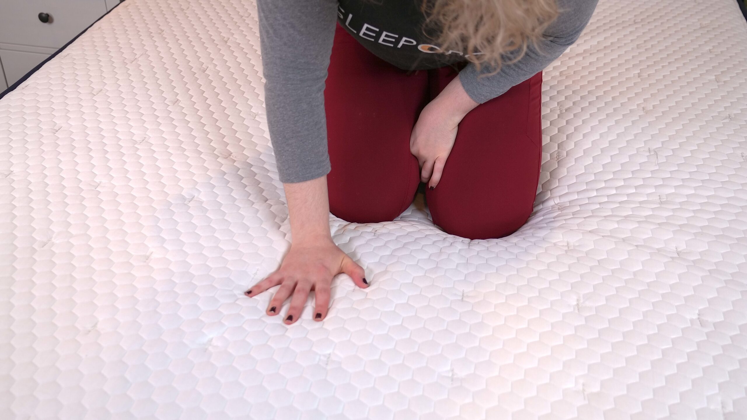 Nichole touching the cover of the Brooklyn Bedding Aurora Luxe Mattress Cover