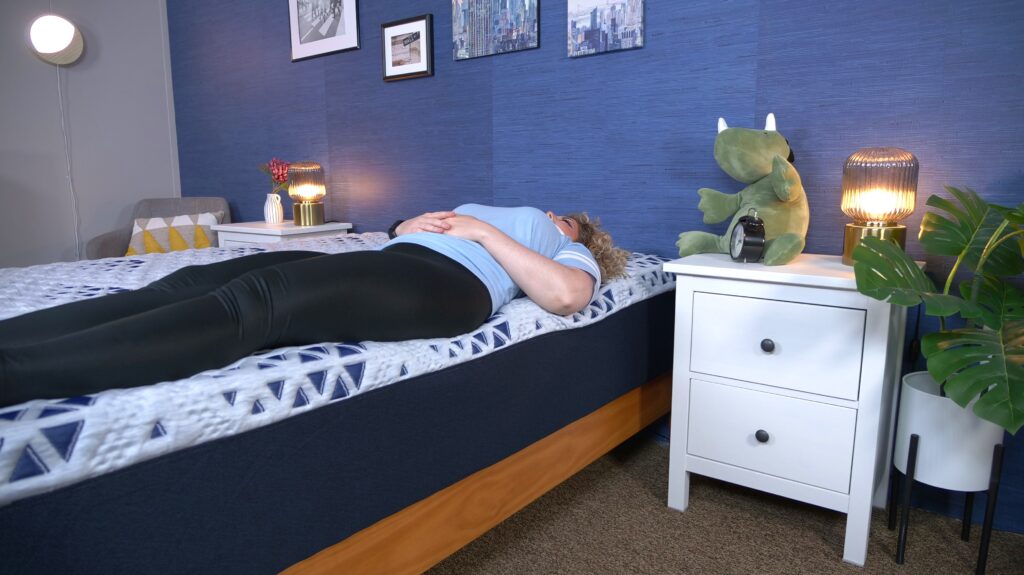 Nichole testing the edge support on the Sleepy's Hybrid mattress.