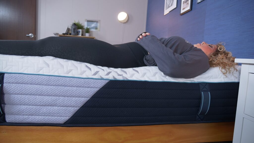 Nichole testing the edge support on the Nectar Premier Hybrid mattress.