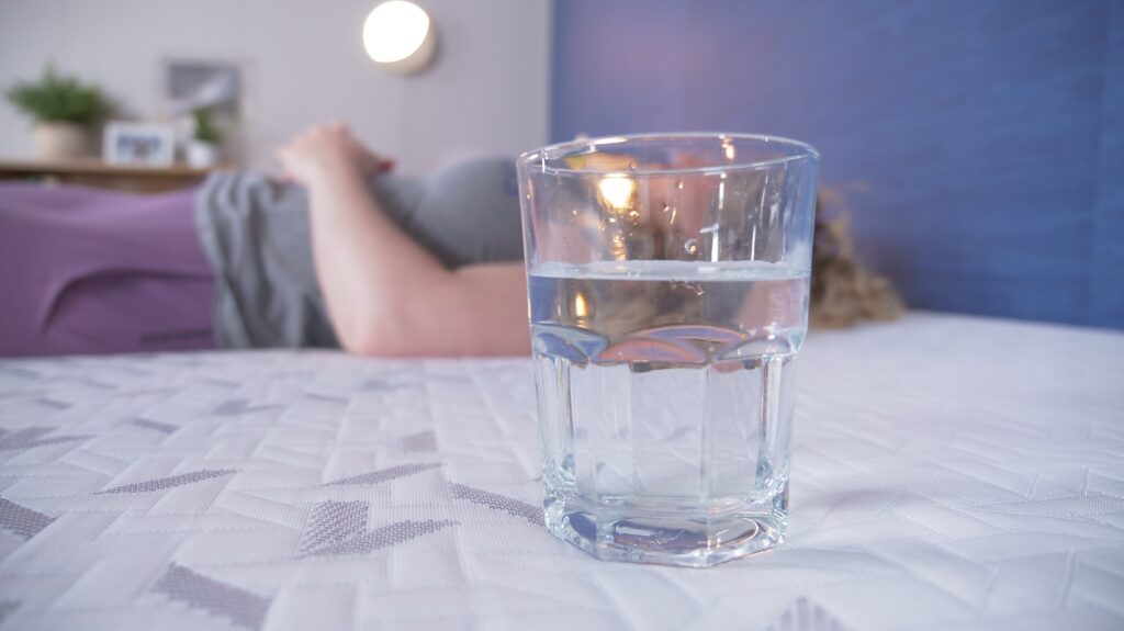 Nichole performing the water test on the Nectar Ultra mattress.