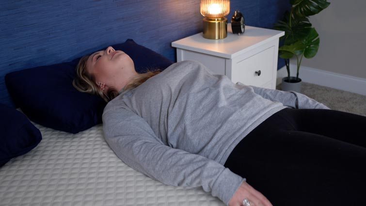 A woman sleeps on her back on a Nolah Signature mattress