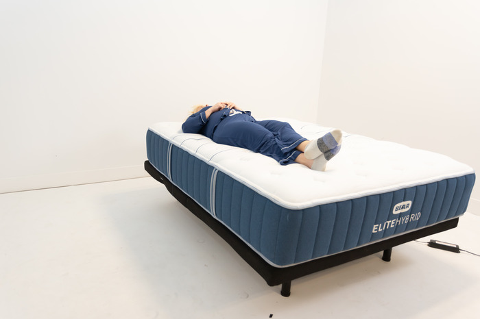 A person side sleeping on a Bear Elite Hybrid mattress.