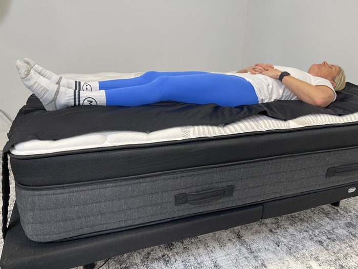 A woman lying on her back on the Nolah Evolution mattress.