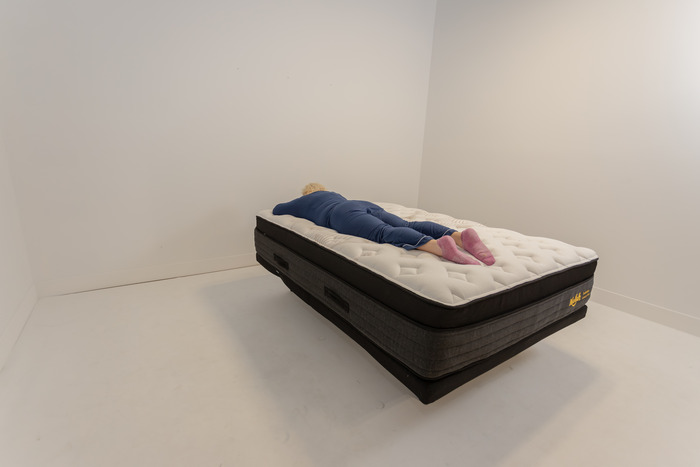 A woman lying on the Nolah Evolution in the stomach-sleeping position.