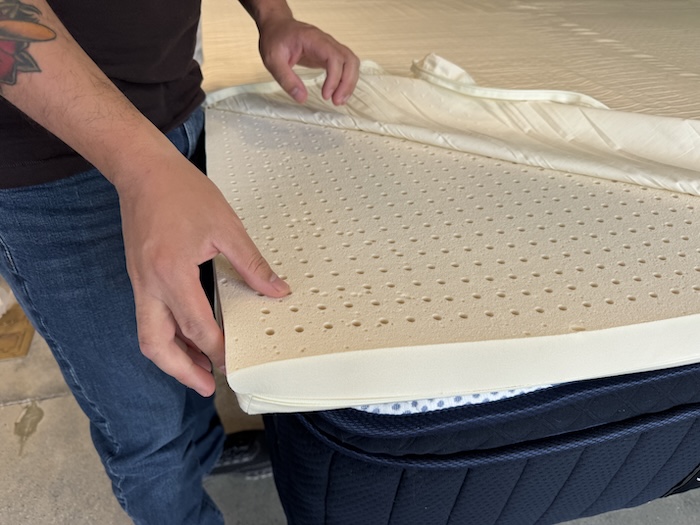 Our tester checks out the latex pad in a mattress topper