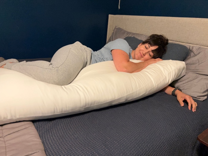 Our expert snuggling with a Cozy Earth Bamboo Down Alternative Body Pillow.