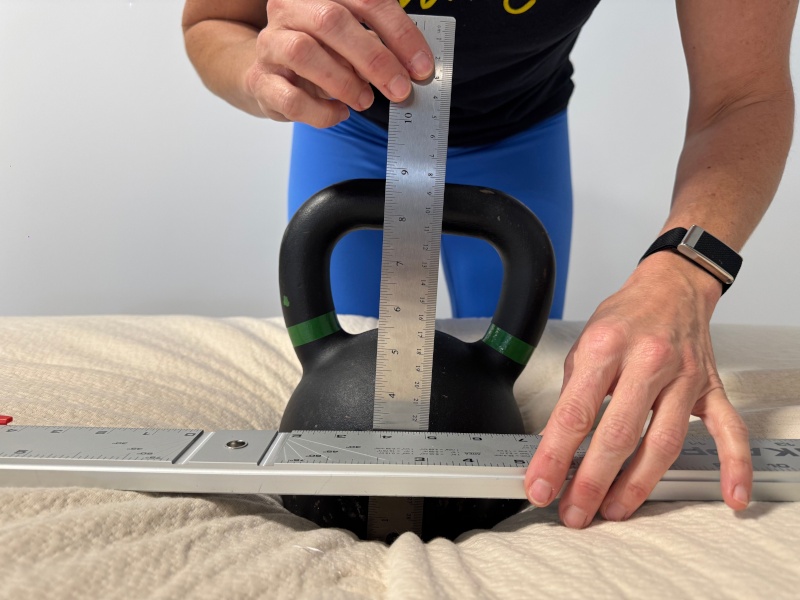 A person performs a sinkage test on the Avocado Eco Organic Mattress