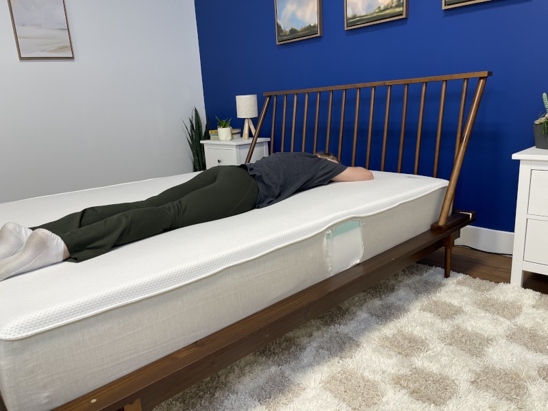 Our tester stomach-sleeping on a Boring Hybrid Mattress