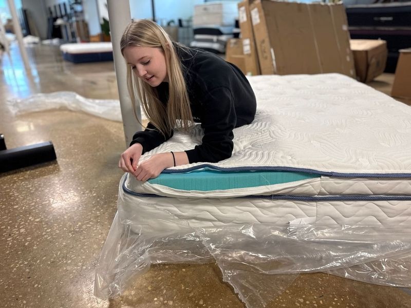 Riley Otis zips up the removable foam pad in the DLX Premier Hybrid mattress.