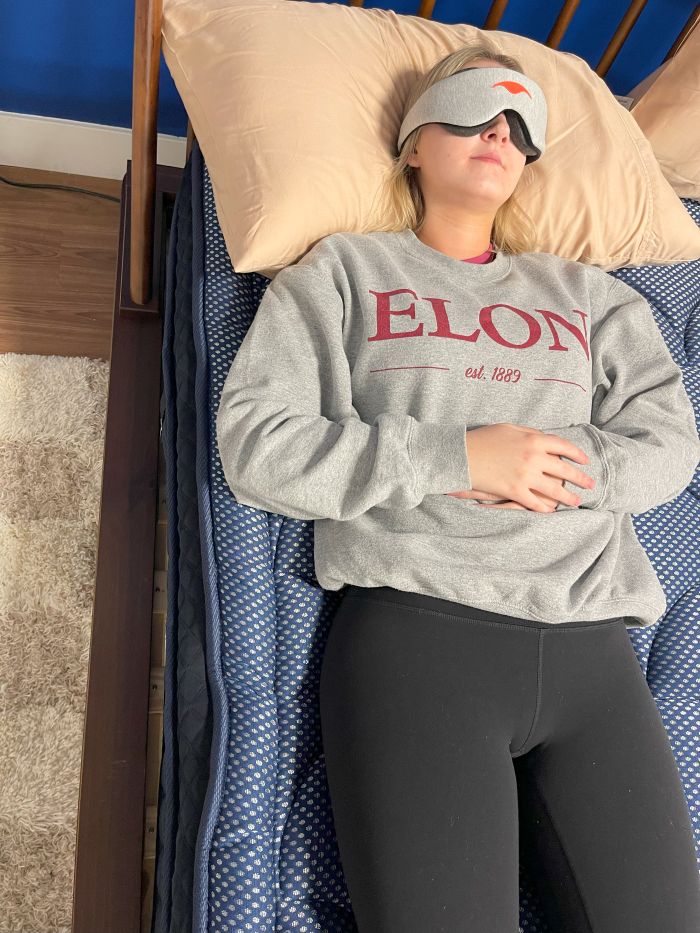 A woman sleeps on her back on the Dreamcloud Luxe Hybrid
