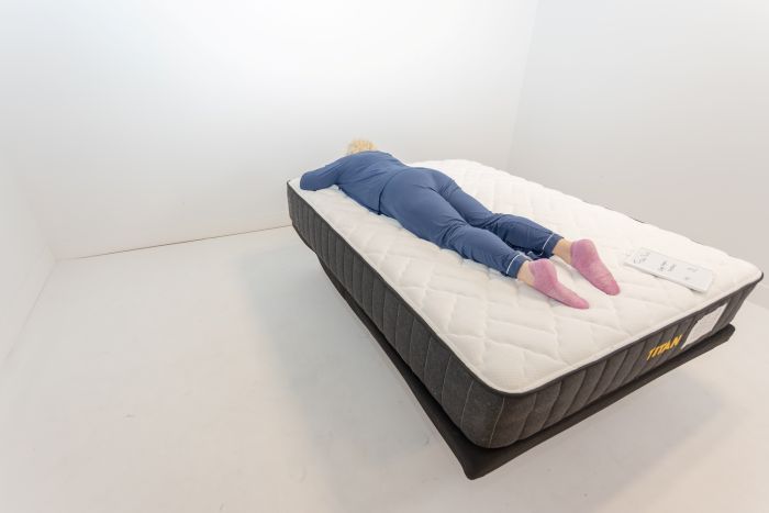 A woman lays on her stomach on the Titan Plus