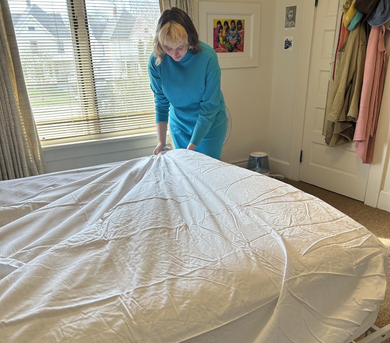 Our tester making a bed with Silk & Snow Egyptian Cotton Bed Sheets