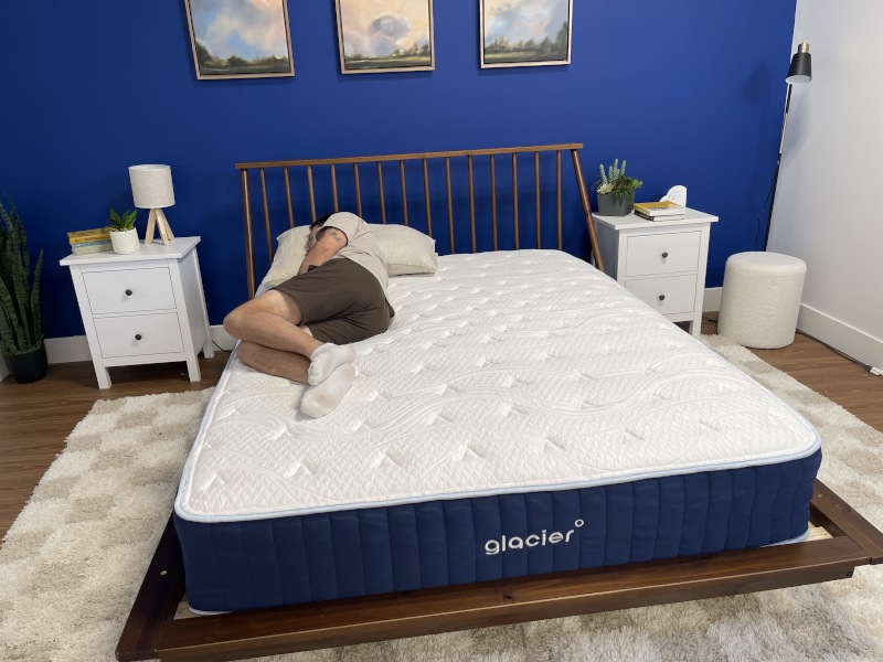 Our tester side-sleeping on a Glacier Original Hybrid Mattress