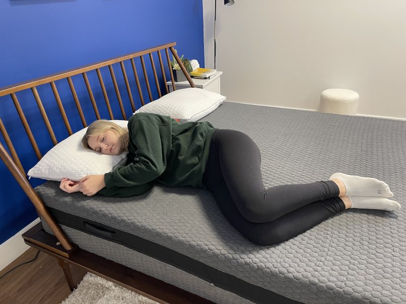 Our tester side-sleeping on a Layla Signature Hybrid Mattress