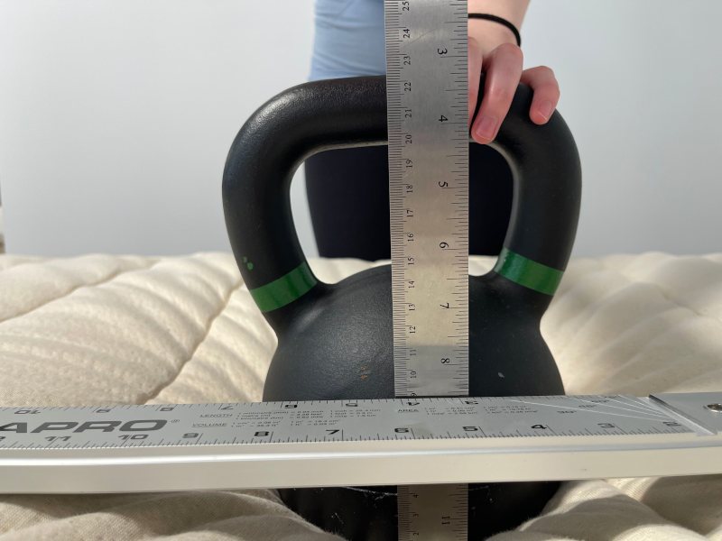 Our tester performs a sinkage test on a Birch Luxe Natural Mattress