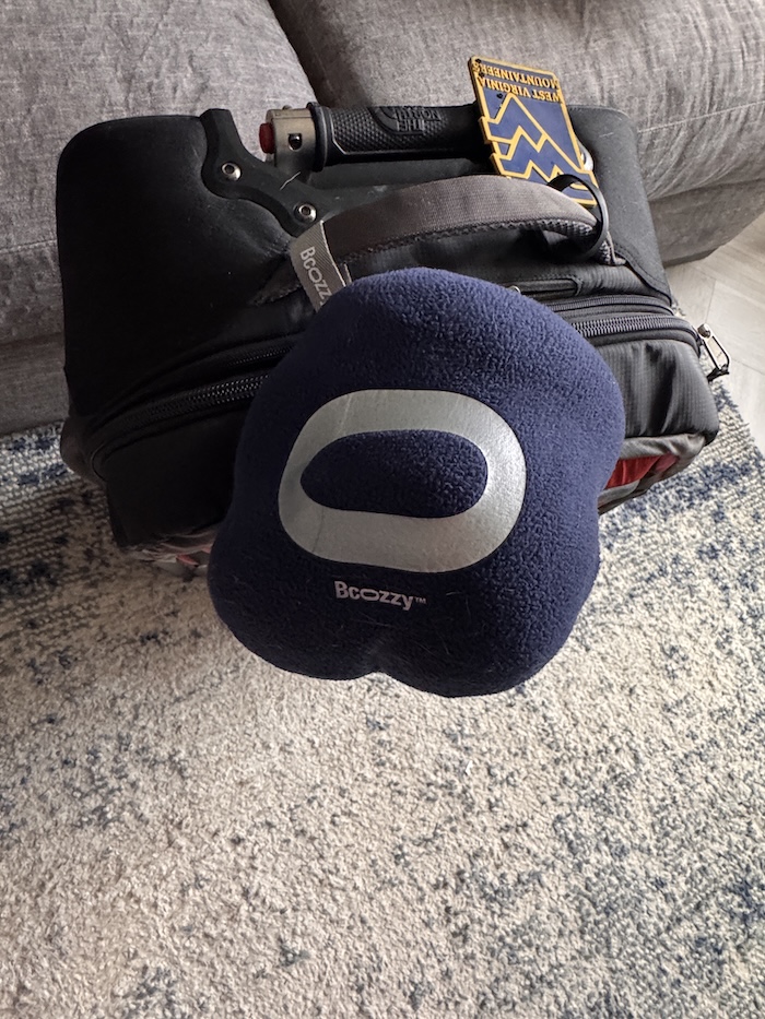 A BCOZZY Travel Pillow attached to a suitcase.