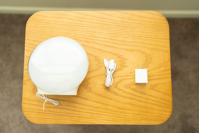 A recently unboxed Jall Sunrise Alarm Clock. The various parts are laid out on a table.
