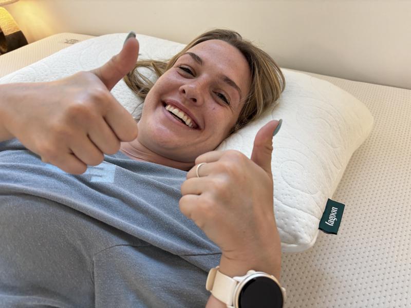 Our tester gives two thumbs up while using a Lagoon The Otter Pillow
