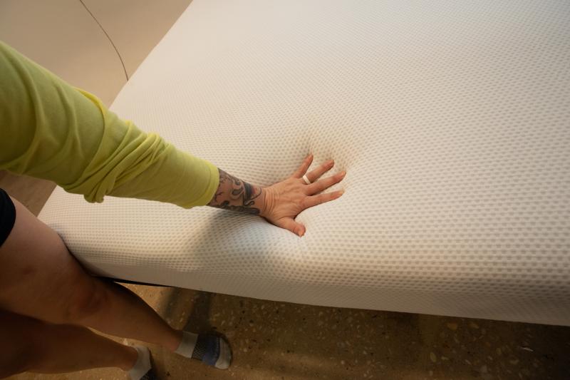 Our tester Sosha Lewis presses her hand into a Zinus Green Tea Memory Foam Mattress