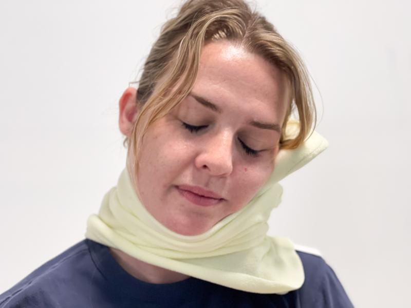 Our tester using the trtl Travel Pillow