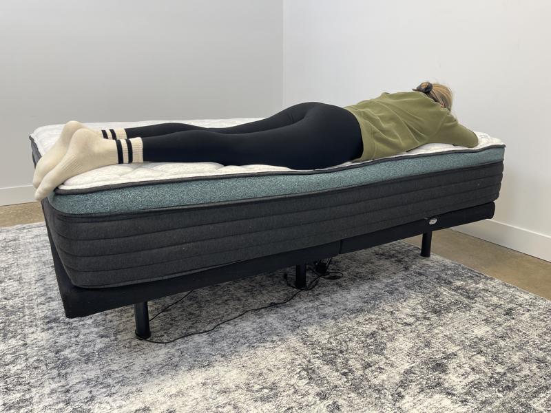 Our tester performs a stomach-sleeping full body edge support test of the Helix Sunset Luxe Mattress
