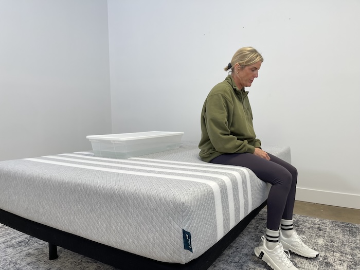 A woman sitting on the edge of the Leesa Original mattress.