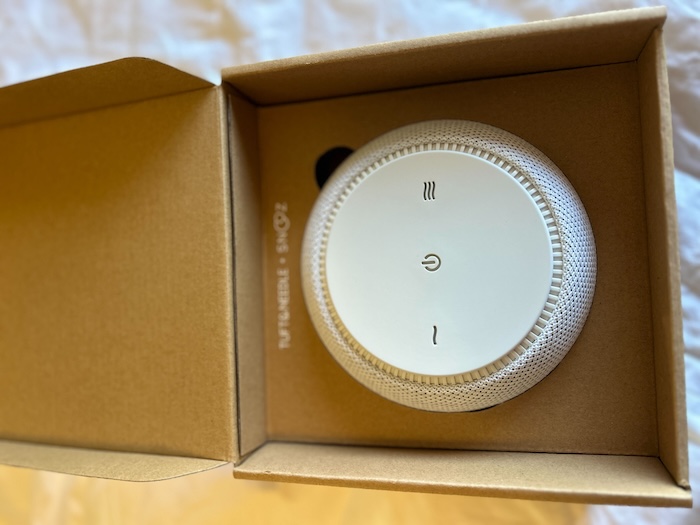 A closeup of an open box revealing the Tuft & Needle sound machine.
