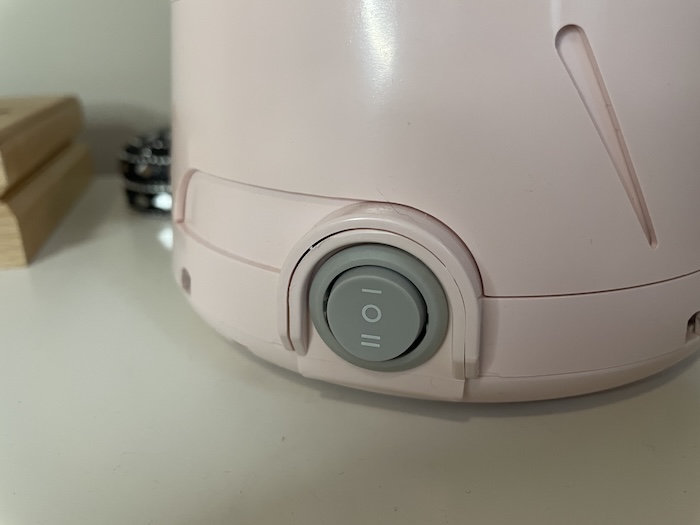 A closeup of the on switch on a Yogasleep Dohm Classic Sound Machine.