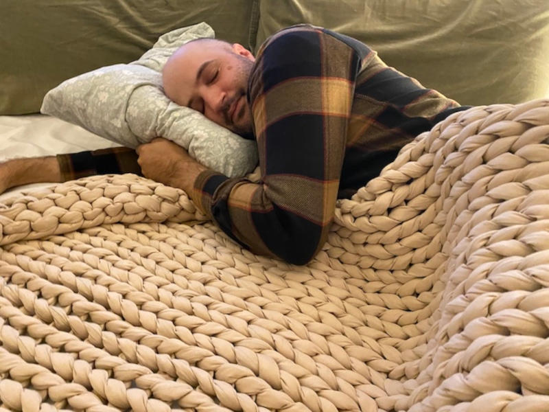 Our sleep expert snuggled up in a Bearaby Weighted Blanket