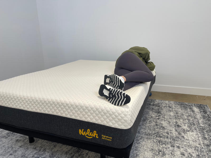 Our tester side-sleeping on the Nolah Signature Mattress