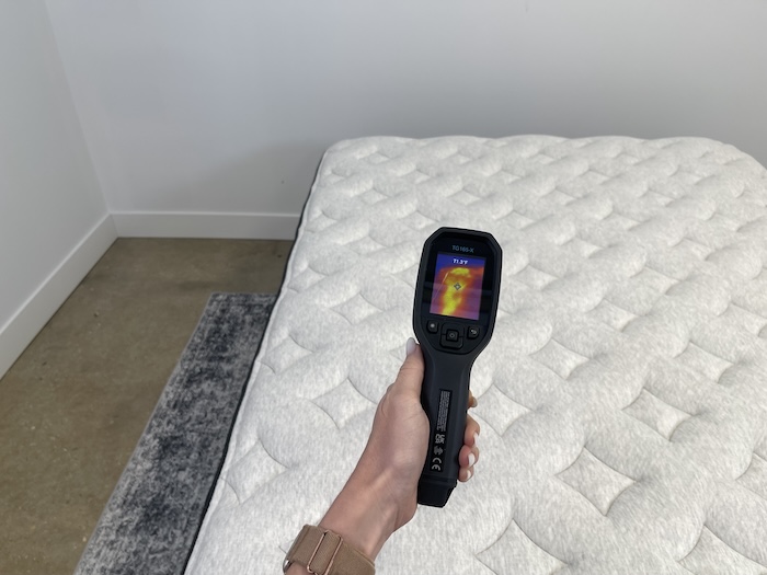 A closeup of someone using a thermal gun to take the temperature of the Helix Dusk Luxe. The screen reads 71.3 degrees.